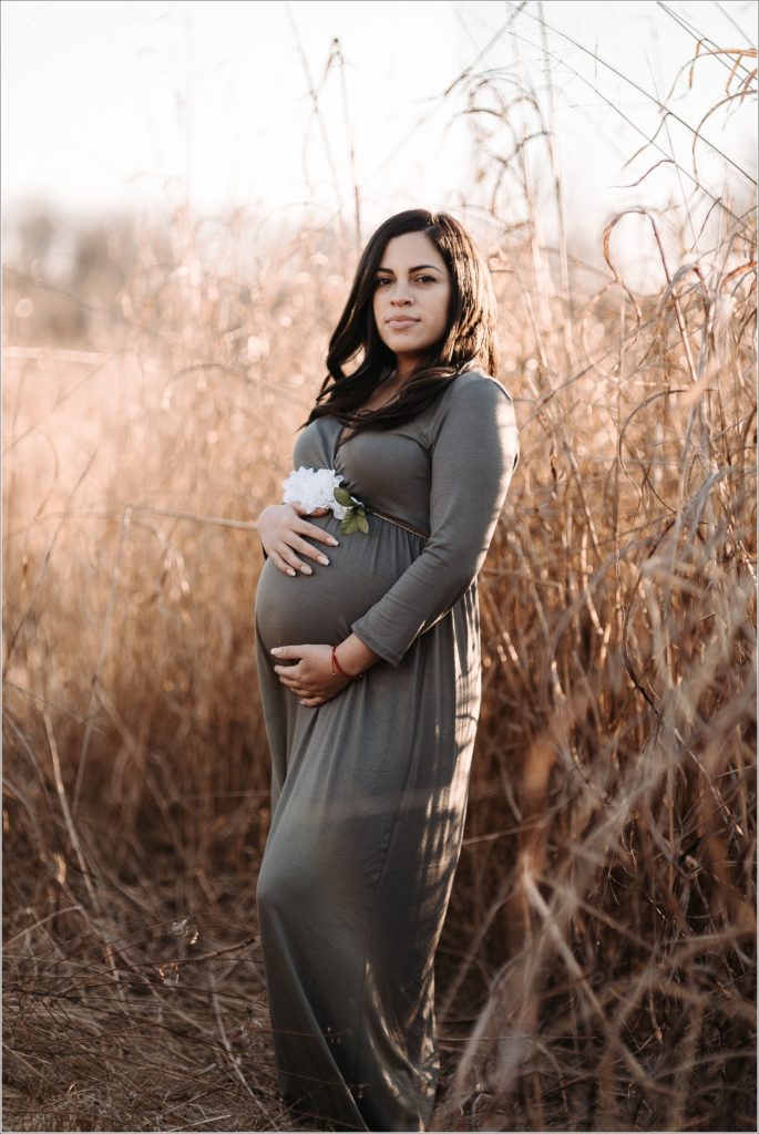 pregnant woman in olive maternity dress in golden field