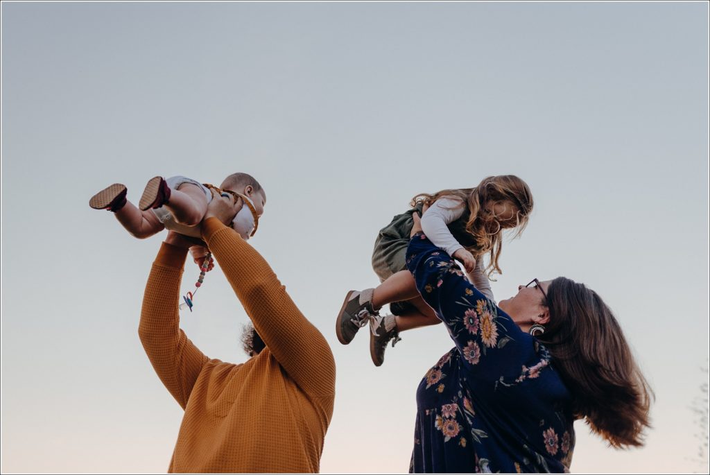 parents hold their kids in the air at sunset for swva photography