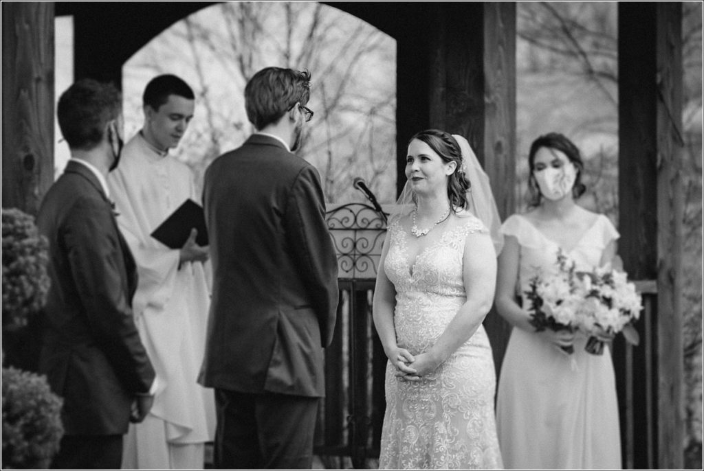 black and white image of bride smiling during ceremony at the barns at chip ridge