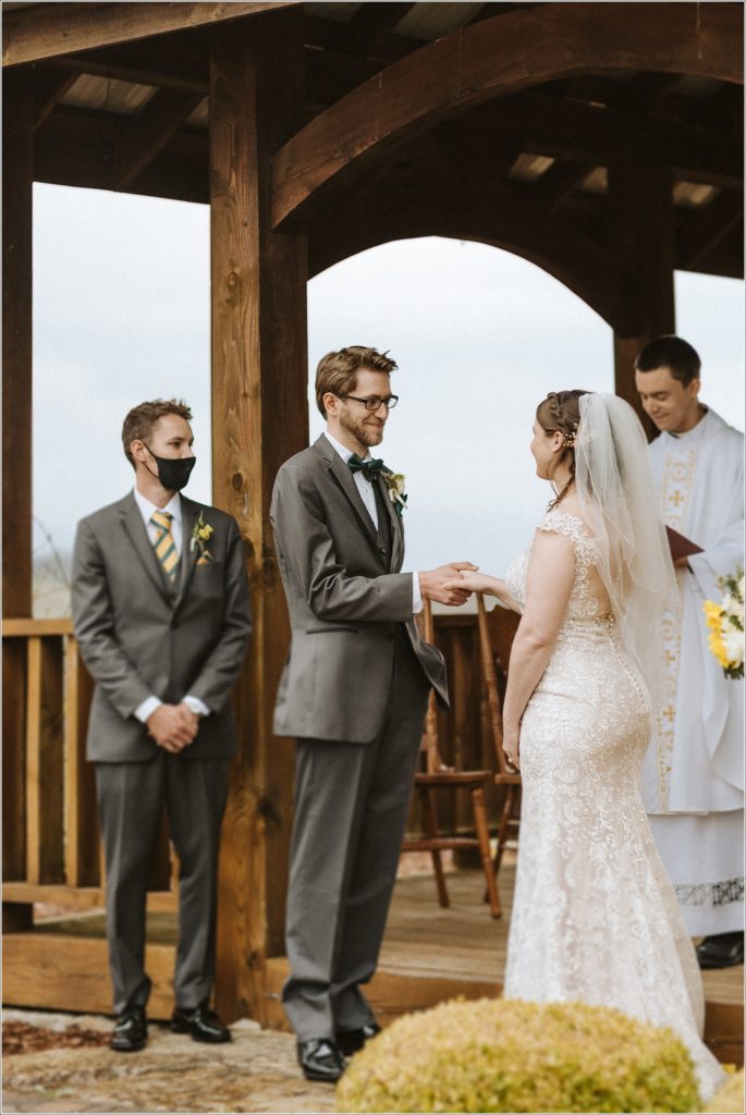 bride and groom take hands during wedding ceremony at the barns at chip ridge