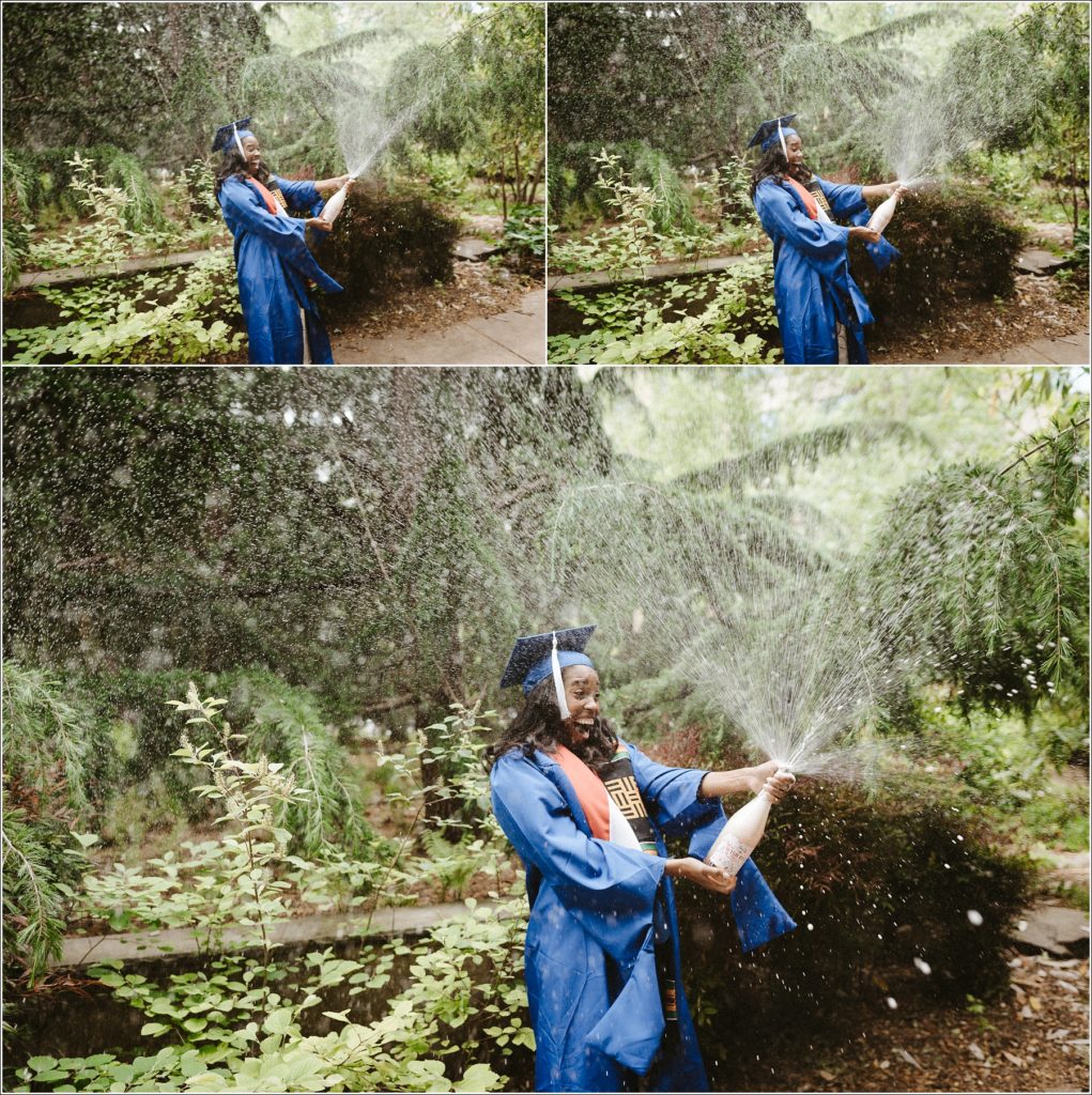 kogod school of business grad in blue cap and gown poses in front of greenery with exploding champagne bottle