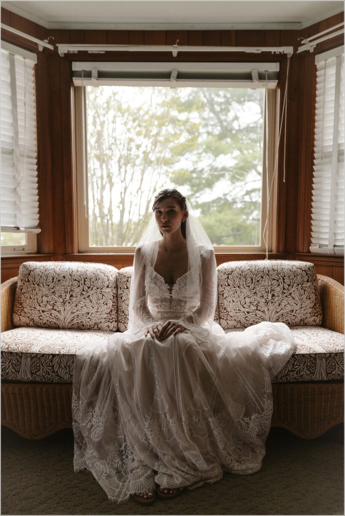 bride sitting on couch for her northeast tennessee wedding in bhldn lace