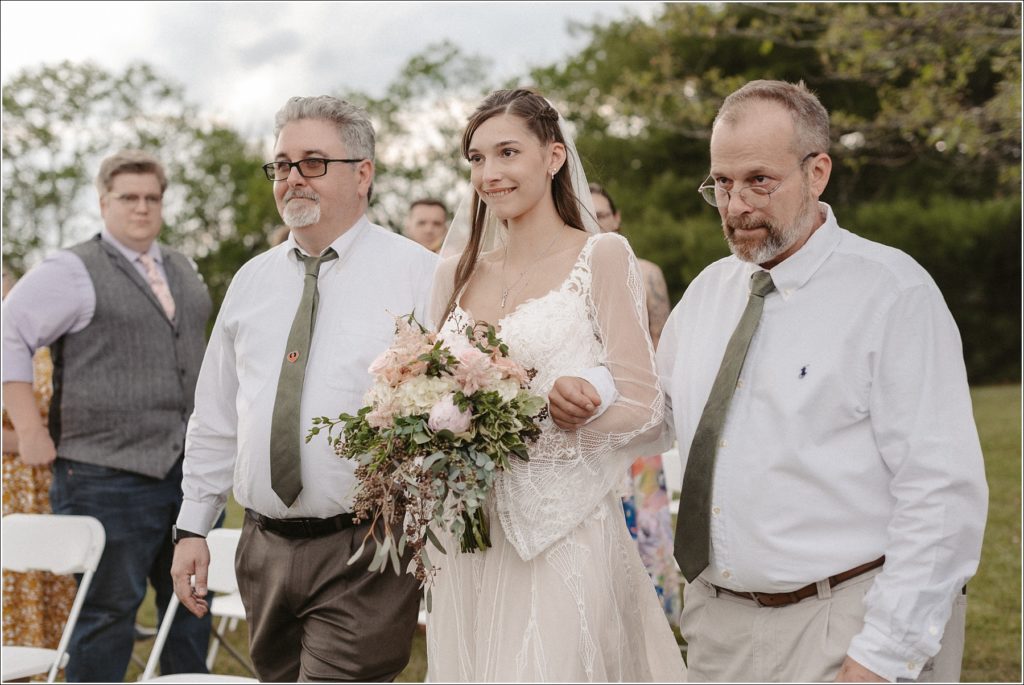bride watches her groom as she is escorted down the aisle by her fathers in bristol tn wedding