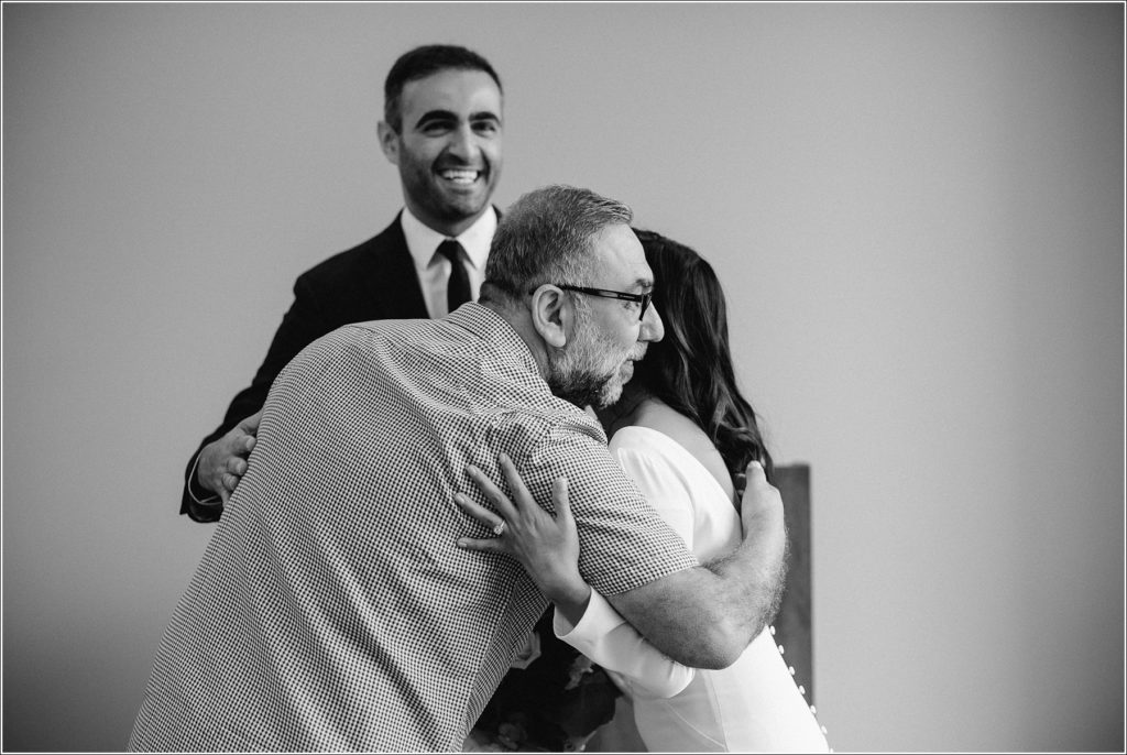 black and white photo of bride embracing friend at maryland elopement