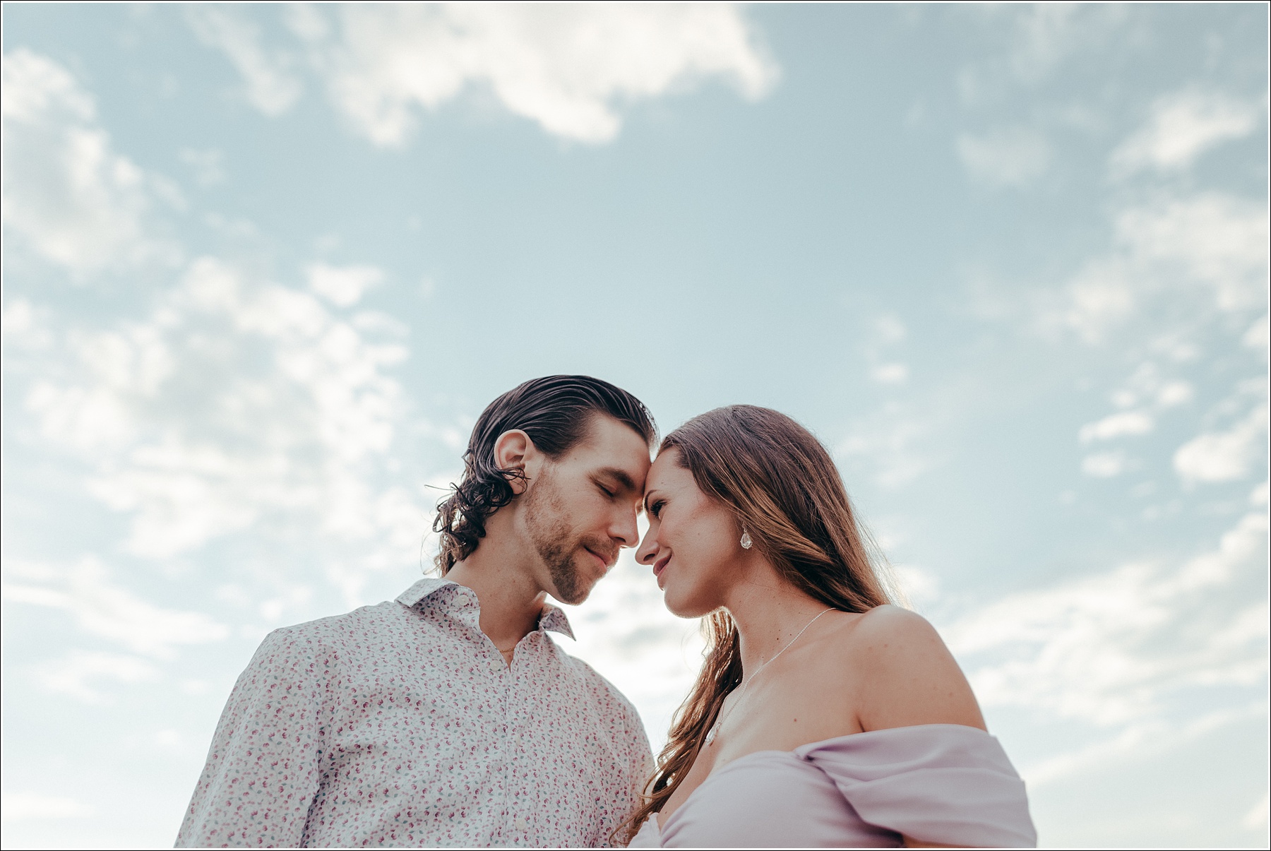 Pregnant woman in lilac maternity dress in Urbana Villages field with her husband