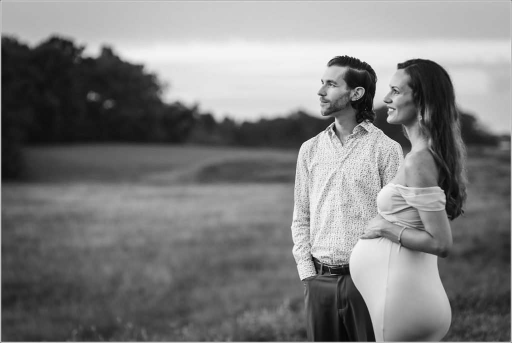 Black and white Pregnant woman in maternity dress in Urbana Villages field with her husband and a rose