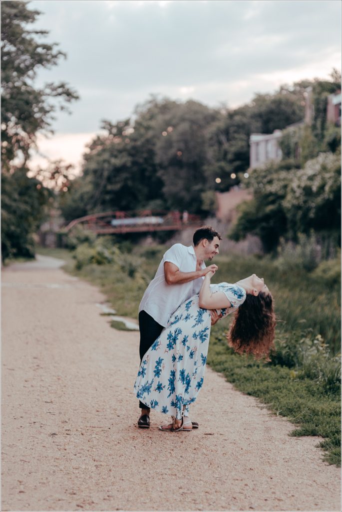 Man dips his fiancé by the C&O canal in white linen summer outfits