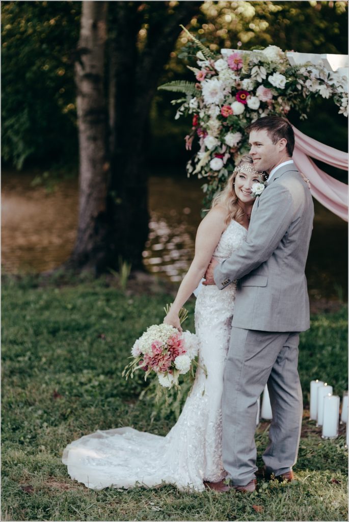 bride and groom pose with florals at vineyard