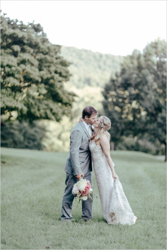 bride and groom pose with florals at vineyard
