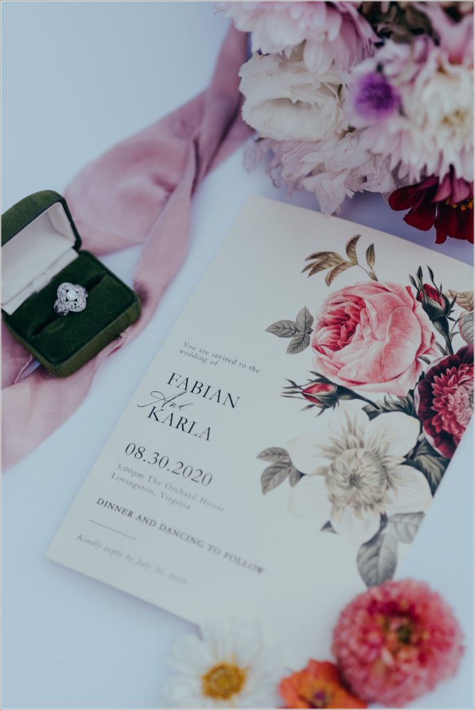 wedding details with green velvet ring box and pink and green florals