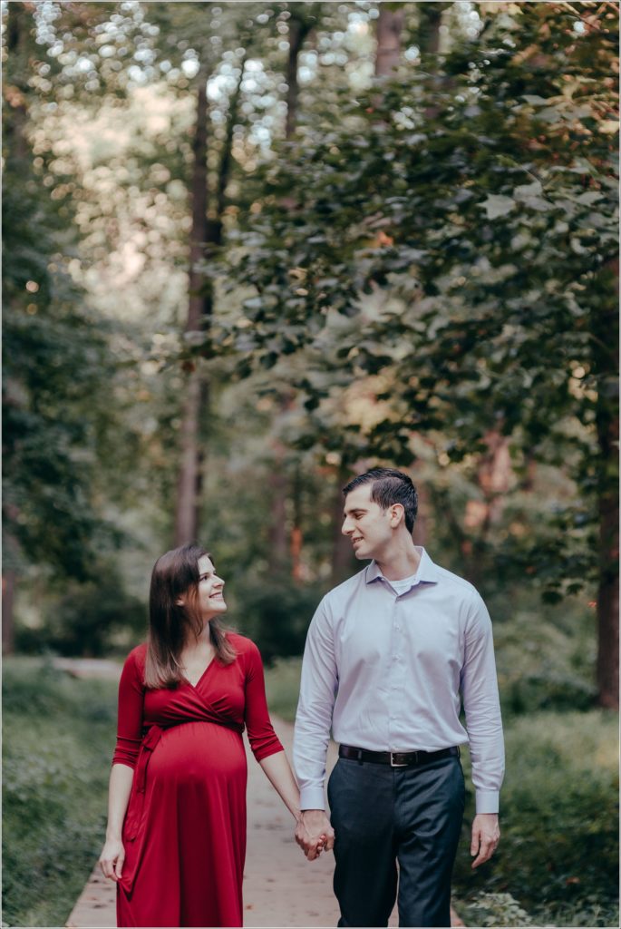 couple poses at sligo creek trail in burgundy maternity dress