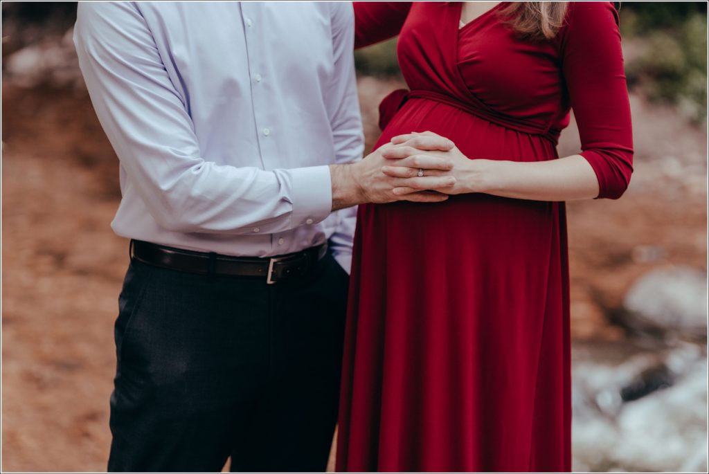 couple poses at sligo creek trail in burgundy maternity dress