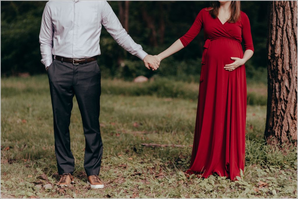 couple poses at sligo creek trail in burgundy maternity dress
