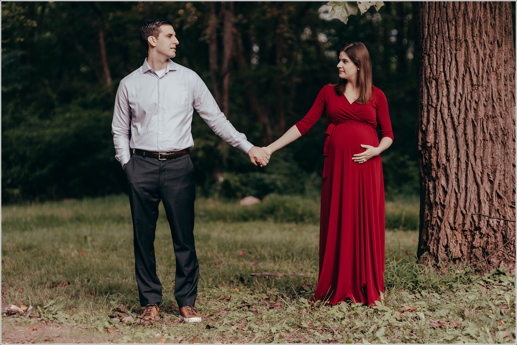 couple poses at sligo creek trail in burgundy maternity dress