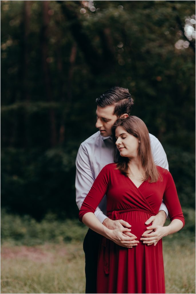 couple poses at sligo creek trail in burgundy maternity dress
