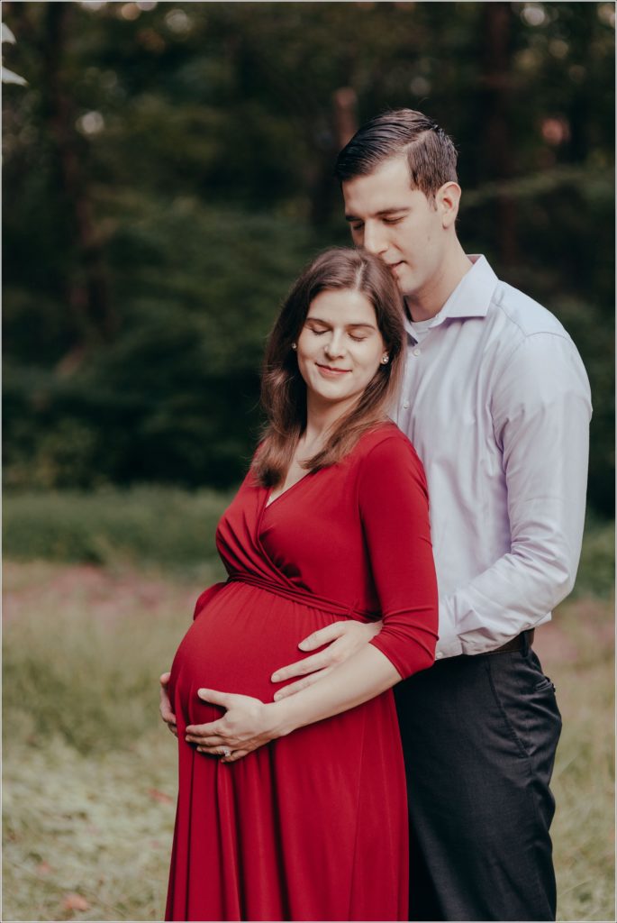couple poses at sligo creek trail in burgundy maternity dress
