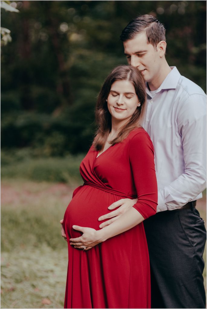 couple poses at sligo creek trail in burgundy maternity dress