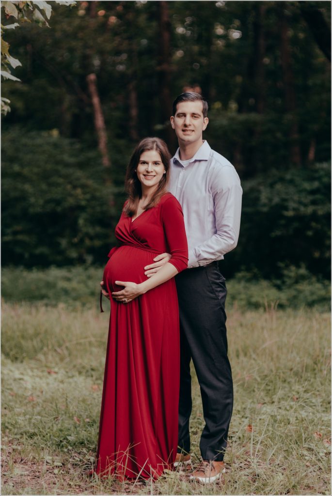 couple poses at sligo creek trail in burgundy maternity dress