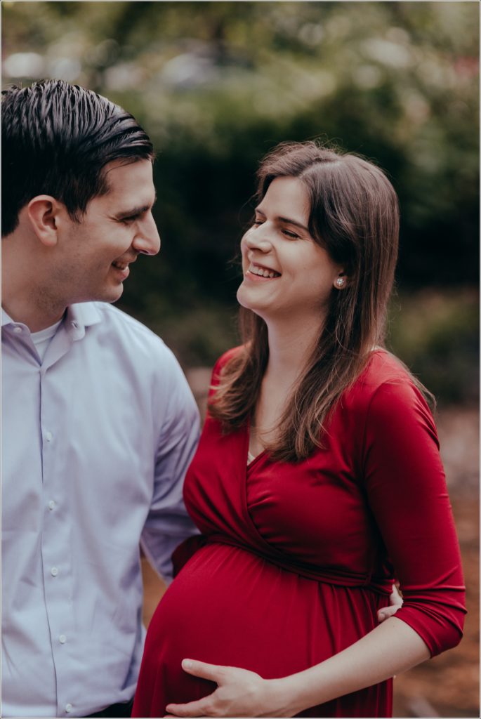 couple poses at sligo creek trail in burgundy maternity dress