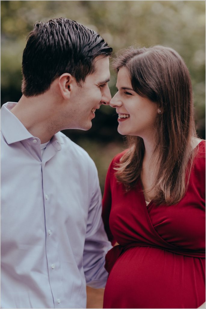couple poses at sligo creek trail in burgundy maternity dress