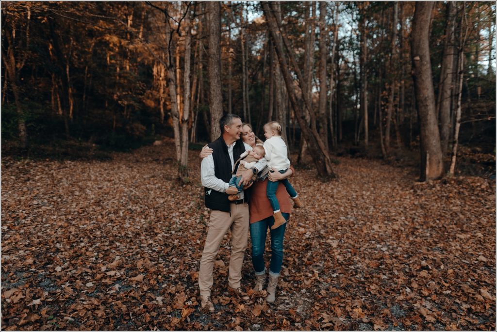 mom and dad embrace kids in fall at abingdon vineyards