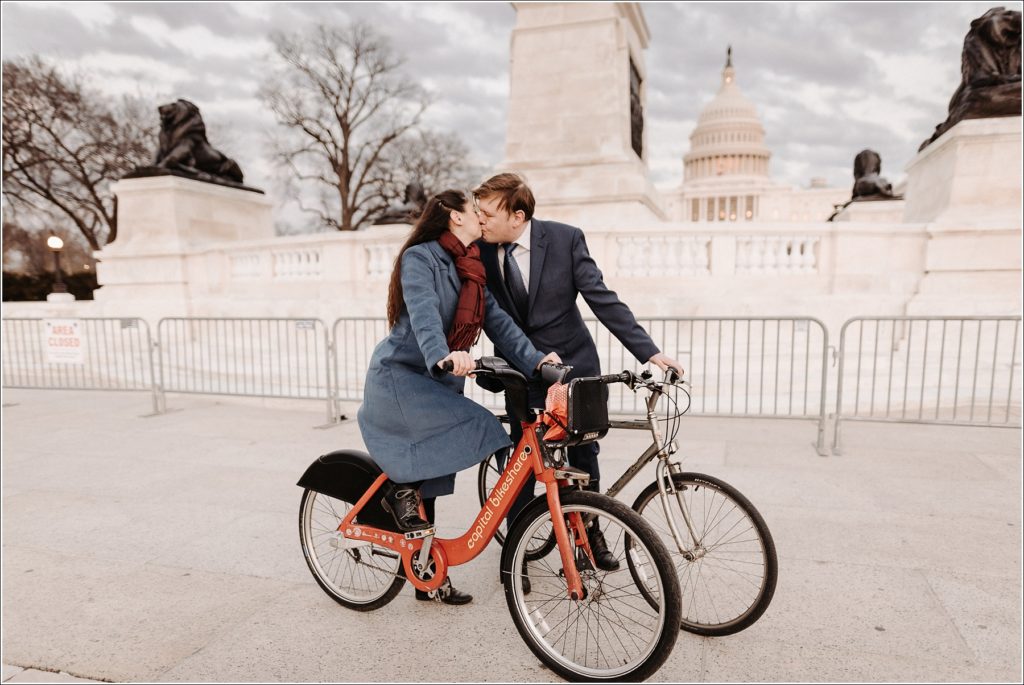 couple kisses on bikes in front of US Capitol for DC elopement