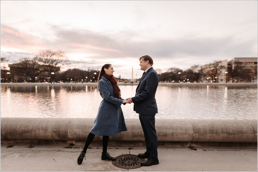 DC elopement couples poses holding hands in front of the water