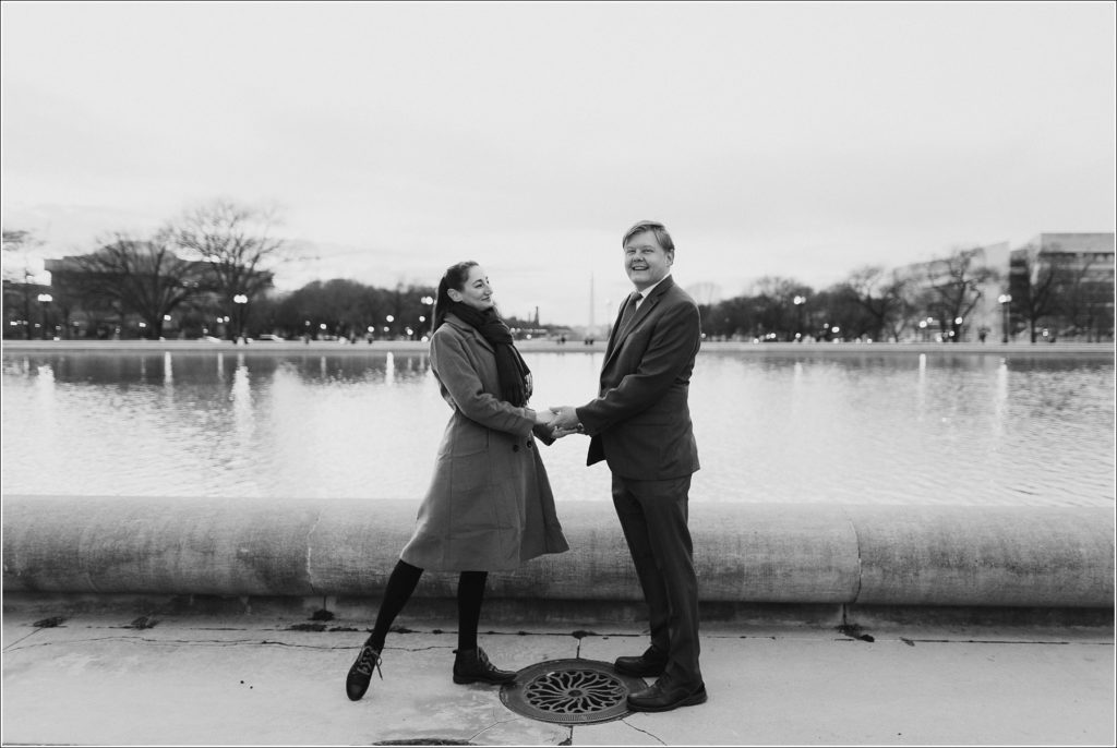 DC elopement couples poses holding hands in front of the water black and white image