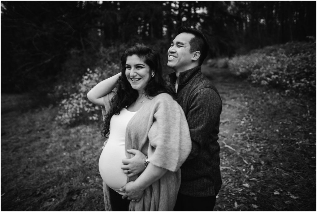 couple poses for maternity photos at Loch Raven Resevoir in black and white