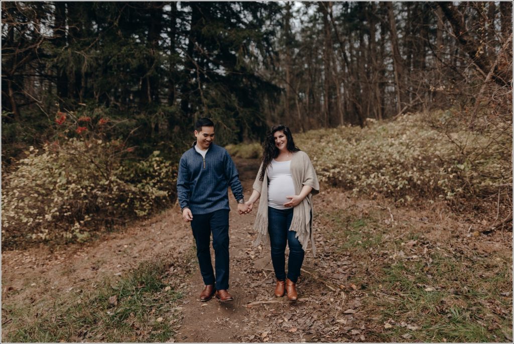 pregnant woman and man walk while holding hands