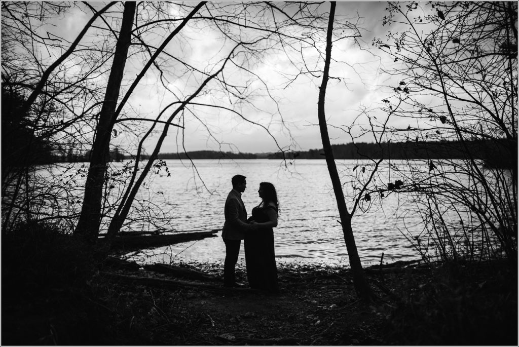 couple poses for maternity photos at Loch Raven Resevoir black and white silhouette