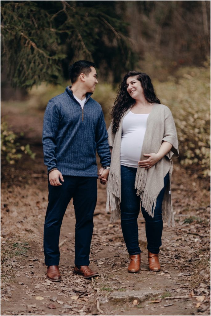 pregnant woman and man hold hands and look at each other