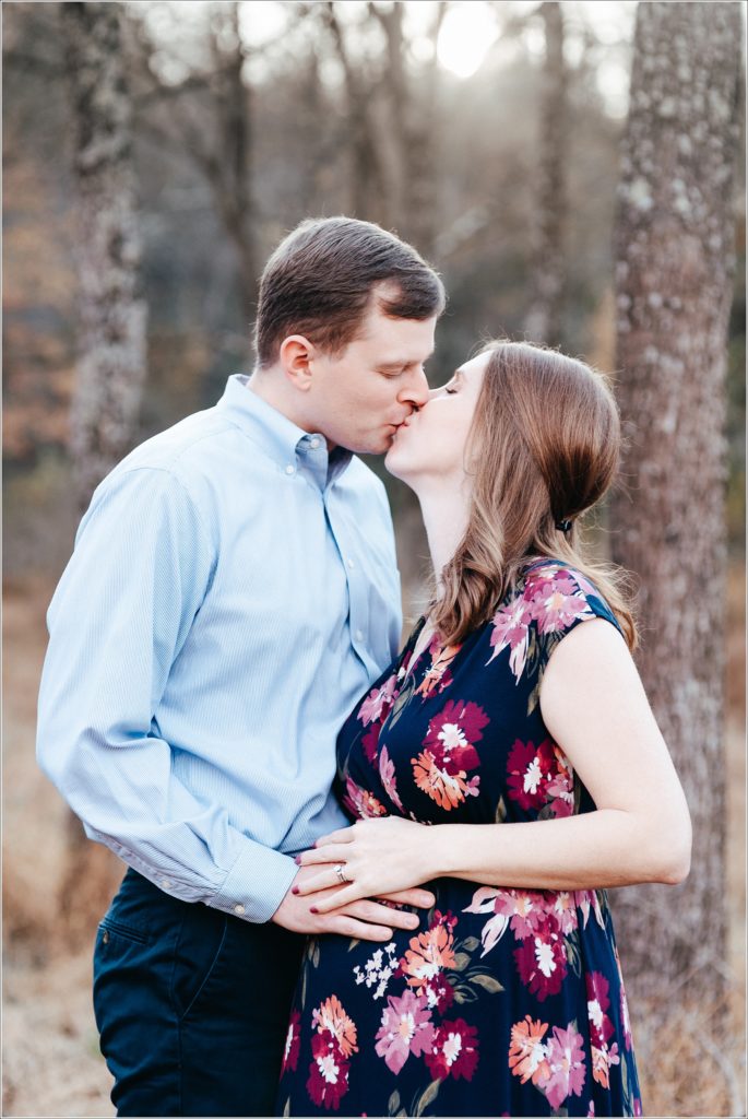 pregnant woman and man kiss in Patuxent River State Park