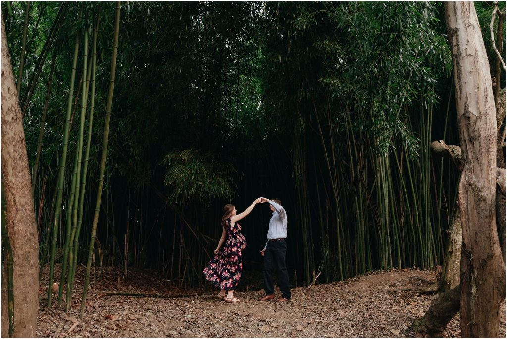 pregnant woman and man dance in front of a bamboo forest at Patuxent River State Park