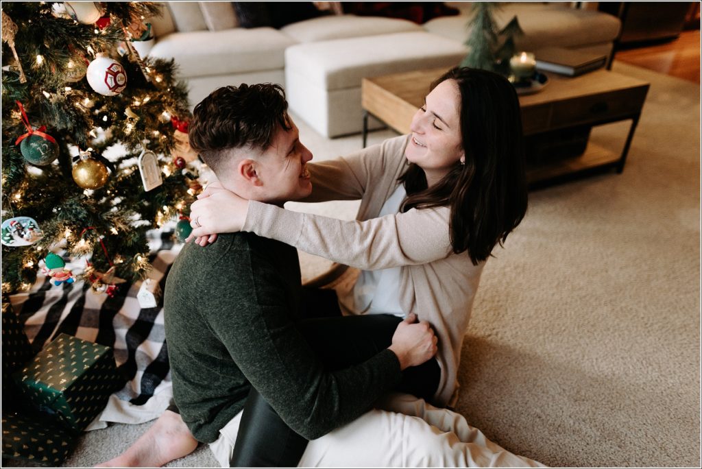 couples christmas photos in their urbana maryland townhouse in front of the christmas tree