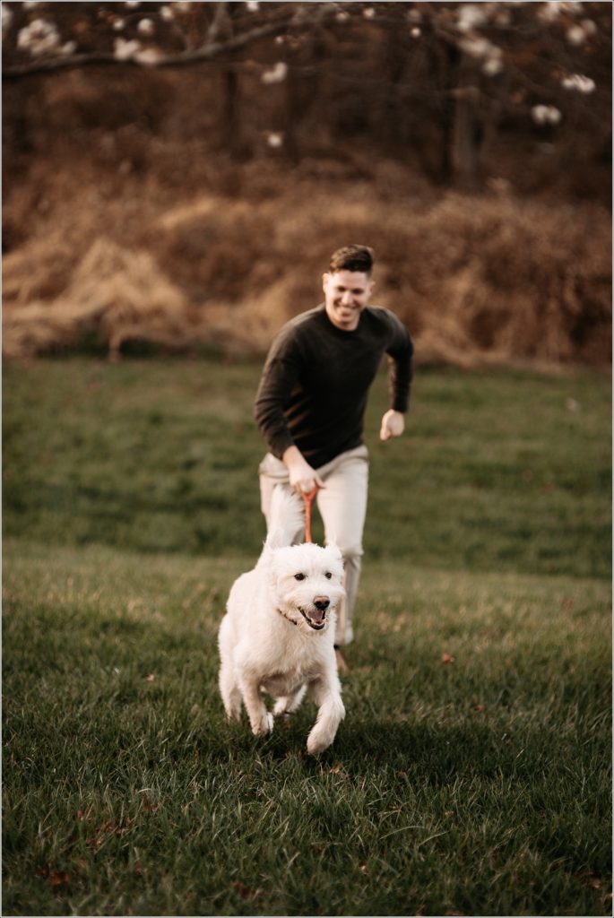 man runs with his labradoodle on green grass in urbana maryland