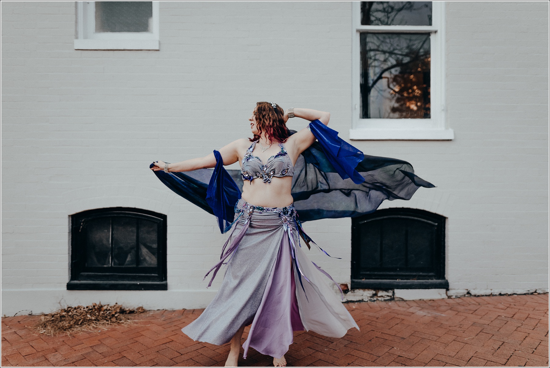 belly dance photoshoot in purple costume on brick sidewalk in frederick maryland