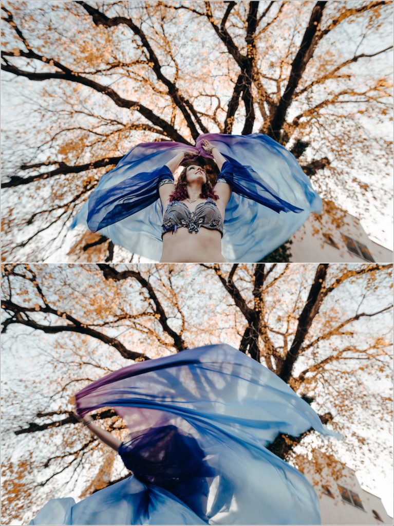 belly dancer photoshoot in blue and purple costume below orange leaves and big tree in frederick maryland