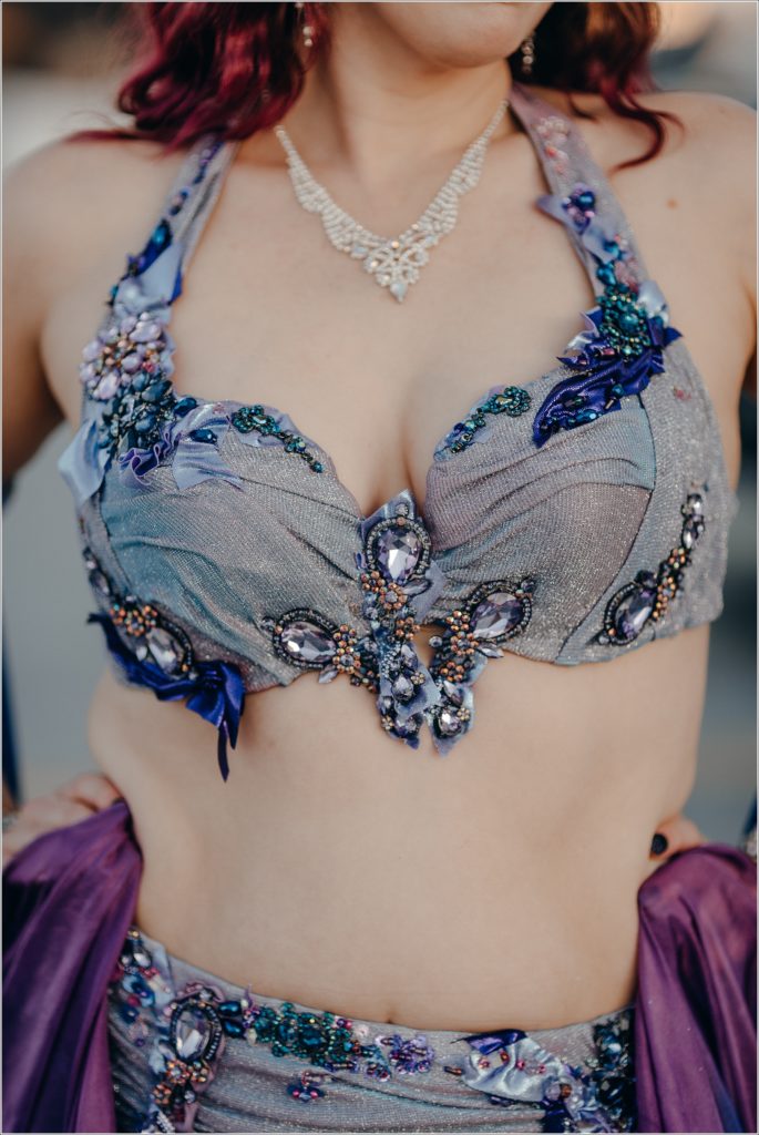 blue and purple belly dance costume against white skin in sunset lighting