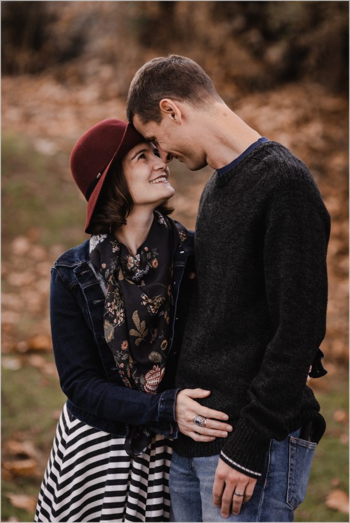 man poses with wife in the fall leaves in thurmont maryland