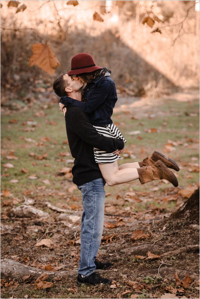 man picks up wife for a kiss in the fall leaves in thurmont maryland