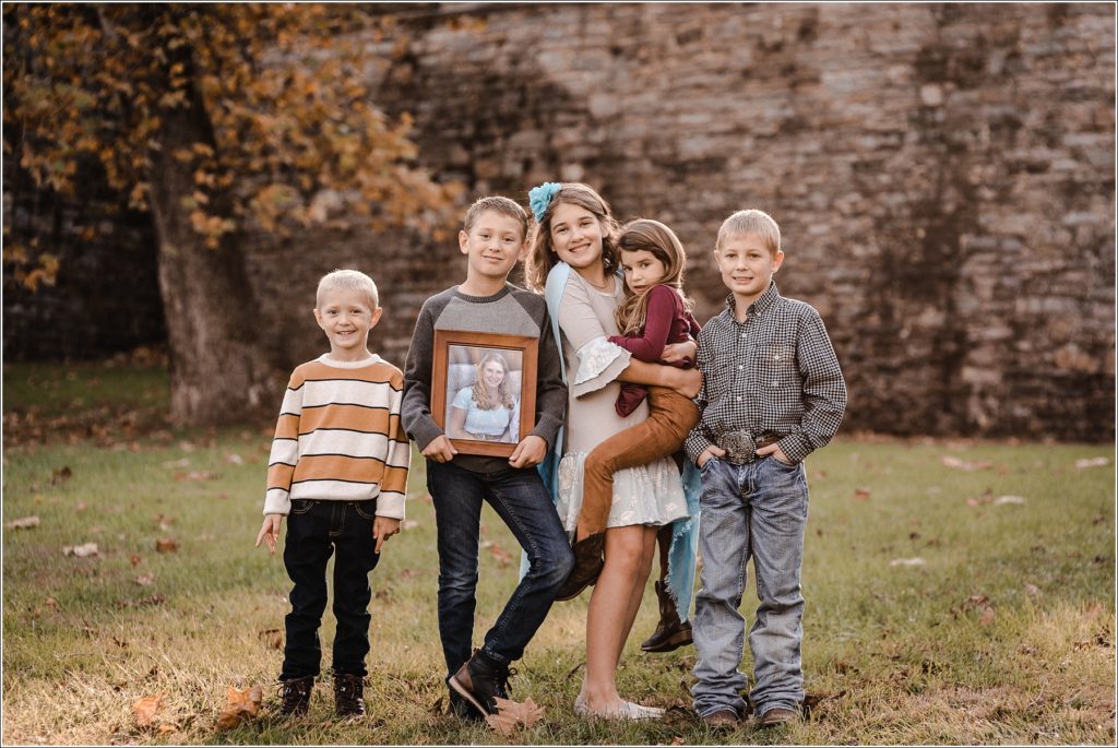 family poses for large family photos in the fall at catoctin furnace at sunset