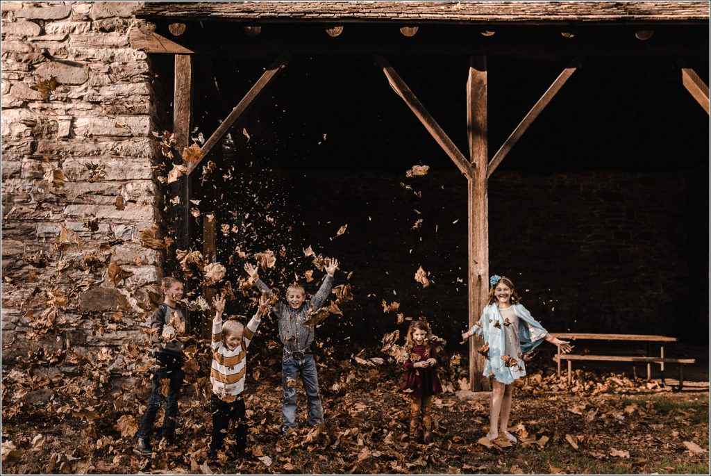 kids throw fall leaves at catoctin furnace