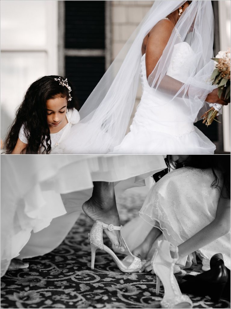 flower girl helps a bride into her shoes and lifts up her dress for her