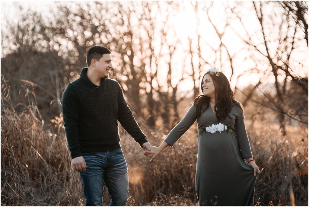 maternity pics of couple holding hands at sunset in frederick maryland
