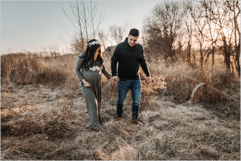 couple poses for maternity pics in frederick maryland at sunset