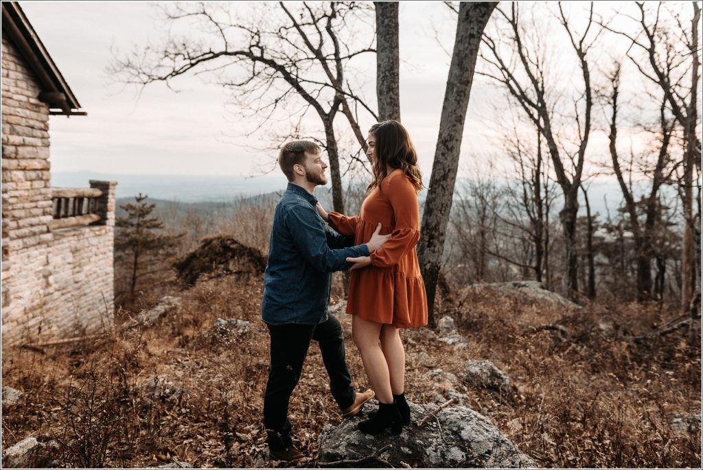 man and woman hold hands at middletown overlook in burnt orange dress and blue jean button down