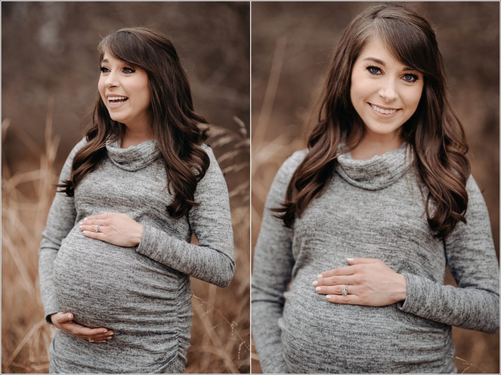 pregnant mama to be poses with hands on her belly in grey maternity sweater dress