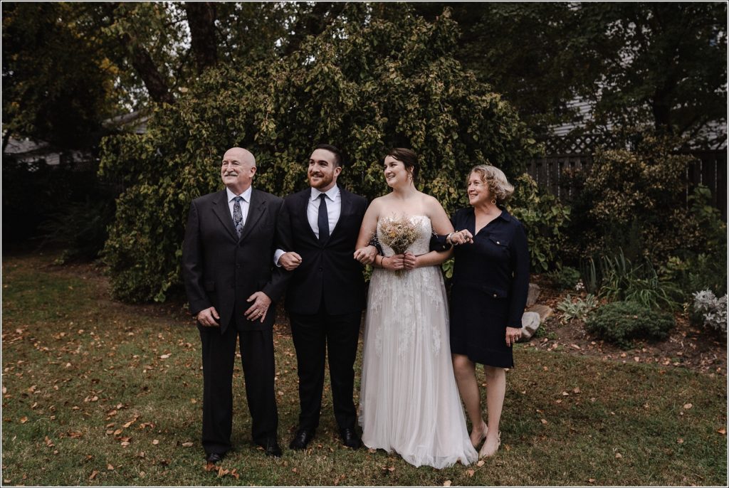 family of four pose for family formals in solomons island wedding looking off to the left