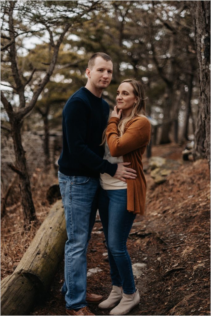 couple in blue and orange sweaters pose at the middletown overlook for firefighter engagement photos
